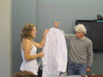 Lauren happily receives her personalized white coat from Dr. Goldberg.